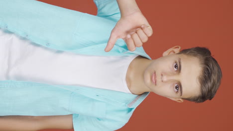 Vertical-video-of-Boy-looking-at-camera-with-a-negative-expression.